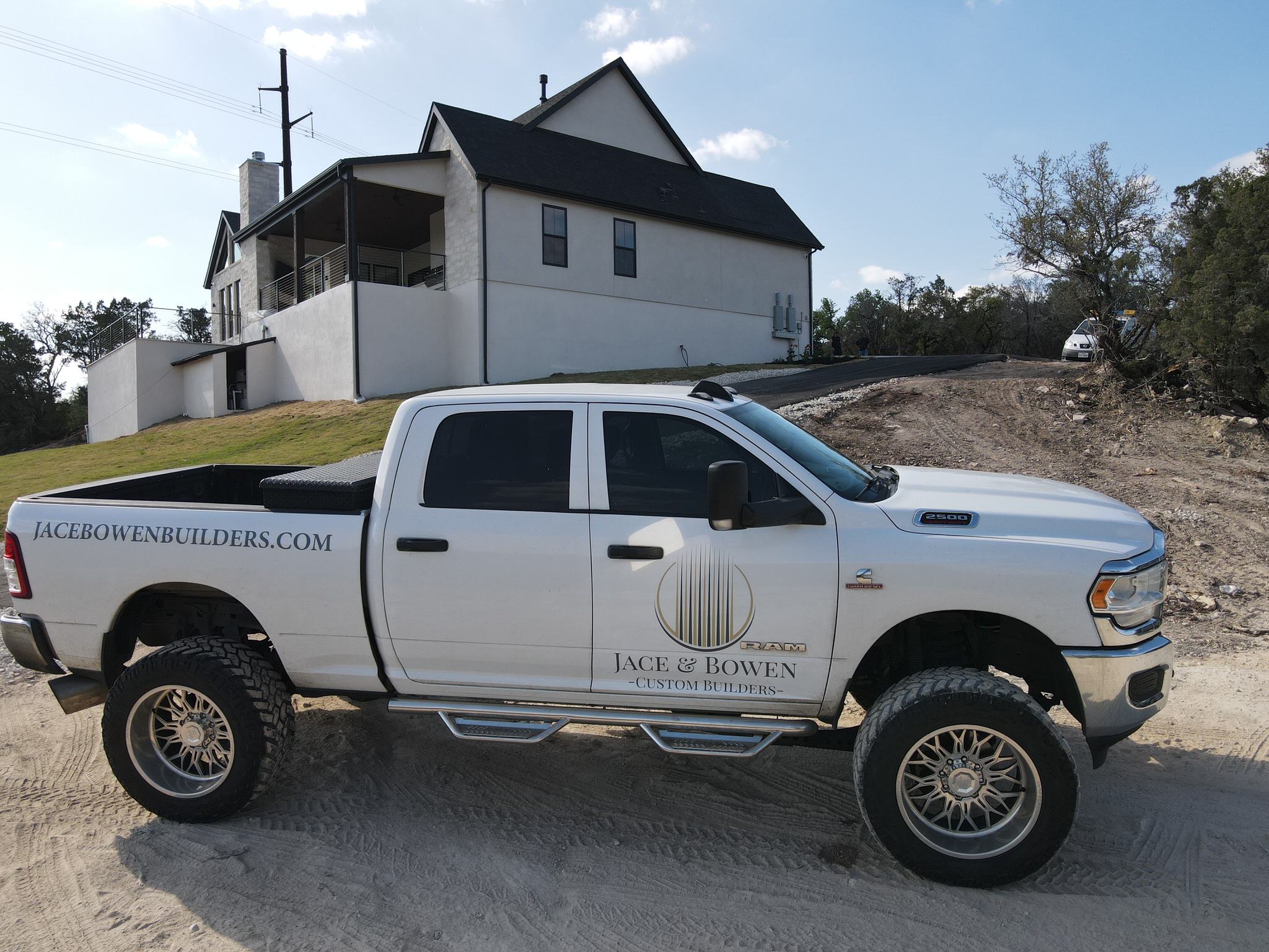 Jace & Bowen Custom Builders business truck in front of a luxury custom home in Lakeway, TX.